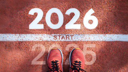 A runner's feet stand at the "START" line for the year 2026, ready for a new race or journey.