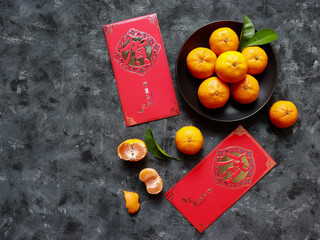 Top view of Mandarin oranges in a plate and two red envelopes for celebrating Chinese New Year