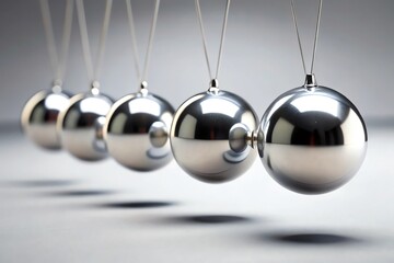 Shiny silver Christmas balls arranged like a Newton's cradle pendulum represent a 3d chrome metal sphere motion concept reflecting gravity and physics in a silver balance of science and action