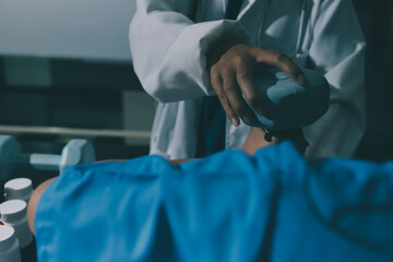 Physical therapist assisting a woman with dumbbell exercise