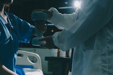 Physical therapist assisting a woman with dumbbell exercise