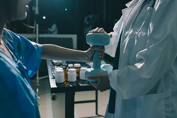 Physical therapist assisting a woman with dumbbell exercise