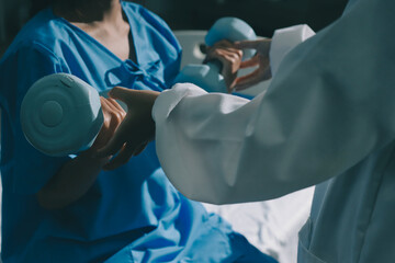 Physical therapist assisting a woman with dumbbell exercise