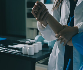 Doctor examining patient's elbow in hospital room