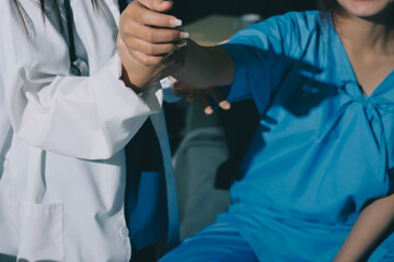Doctor examining patient's elbow in hospital room