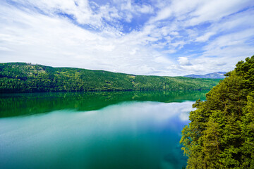 View of Lake Millstatt and the surrounding green landscape. Idyllic nature by the lake north of the Drava Valley near the town of Spittal an der Drau in Carinthia.

