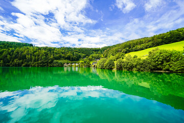 Fototapeta premium View of Lake Millstatt and the surrounding green landscape. Idyllic nature by the lake north of the Drava Valley near the town of Spittal an der Drau in Carinthia. 