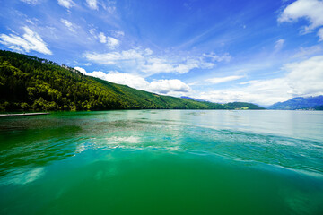 Obraz premium View of Lake Millstatt and the surrounding green landscape. Idyllic nature by the lake north of the Drava Valley near the town of Spittal an der Drau in Carinthia. 