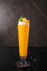 Vibrant Orange Cocktail on Black Marble.