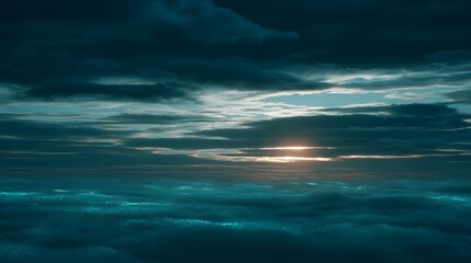 Dramatic sunset viewed through dark heavy clouds over a textured deep blue ocean