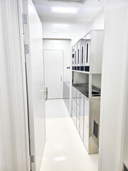 Cleanroom corridor with stainless steel cabinets and doors, sterile laboratory environment.
