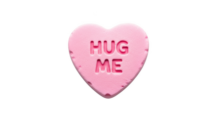 Pink heart shaped candy with the words Hug Me embossed on it against a black background love