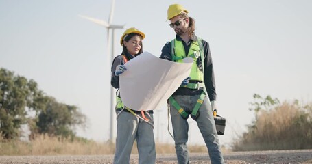 Wind turbine technician collaborate to examine blueprint on wind farm. Highlighting technical expertise and planning required in renewable energy sector to maintain, develop wind power infrastructure
 - Powered by Adobe