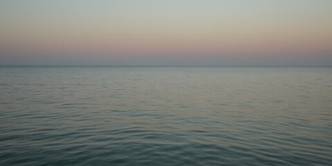Obraz premium Sanftes Meer bei Sonnenuntergang mit zartem Farbenspiel