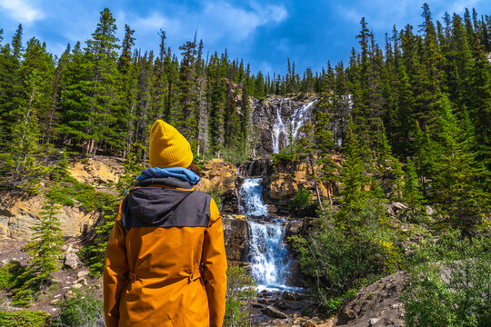 Hiker admiring tangle creek falls in jasper national park, canadian rockies
