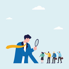 Businessman looking for employees by observing a group of people using a magnifying glass