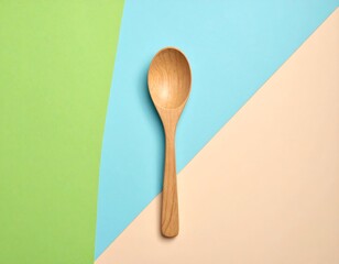 Wooden spoon on a split-color pastel background