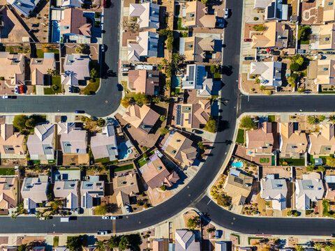 Top down drone view of Los Angeles suburban streets with detached houses and driveways