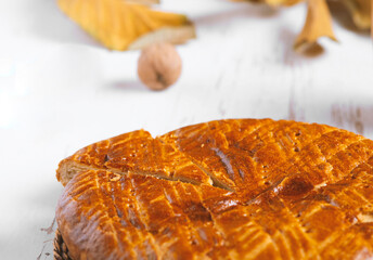 Homemade baked pie served on a shabby table with a cup of tea with autumn leaves and walnuts ,...
