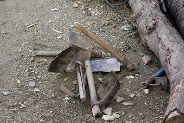 Old Rusty Farming Hand Tools on Ground with Wooden Handles