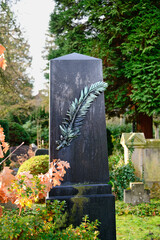 alter schwarzer Grabstein mit einem Palmwedel mit Patina alter Friedhof in Essen-Werden