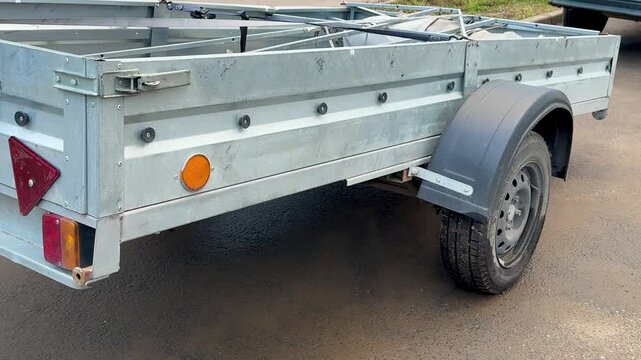 Closeup Of Worn Trailer Parts, Detail View Of Aged Trailer With Rusted Components And Hitch, Close Examination Of Weathered Trailer Showing Corroded Parts And Wornout Taillight