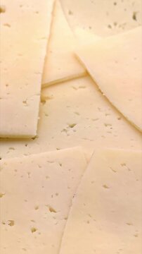 Slices of tasty fresh yellow cheese, dairy product, breakfast ingredient, vertical video
