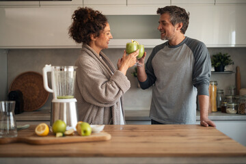 Couple Toasting Green Smoothies in Modern Kitchen, Sharing Joyful Morning Moment
