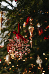 Natural spruce branches decorated with red velvet Christmas bows and gold snowflake, New Year magic details