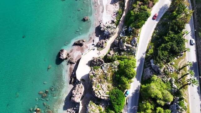 Aerial drone cinematic video of beautiful beach with wonderful seaside promenade of Kato Petres featuring Cave Archangel Michael Panormitis, Rhodes island, Dodecanese, Greece