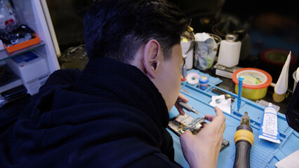 Technician repairing smartphone screen on the workbench.