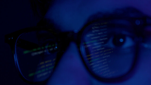 Close up of man's face with binary code reflection on glasses - Powered by Adobe