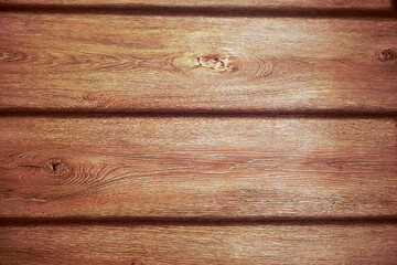 Wooden wall made from natural timber planks with visible grain, knots and warm brown color for rustic interior decor or background.