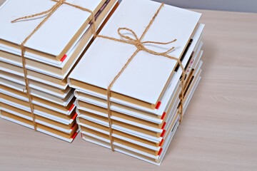 Stack of books with pristine white covers wrapped with natural twine for a rustic aesthetic. Concept of education, learning, or gifting.