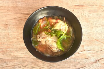 spicy chicken meat with onion and tomato in tom yum soup on bowl