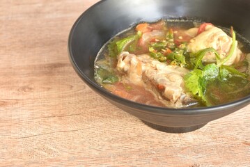 spicy chicken meat with onion and tomato in tom yum soup on bowl