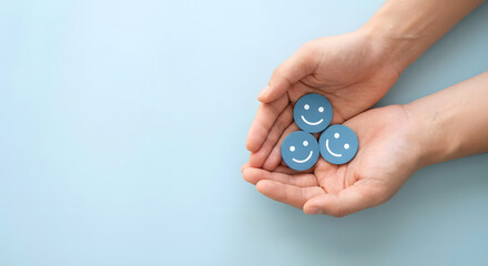 Hands holding blue smiley faces on a light blue background