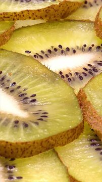 Kiwi fruit slices. Fresh healthy snack textured background, vertical video
