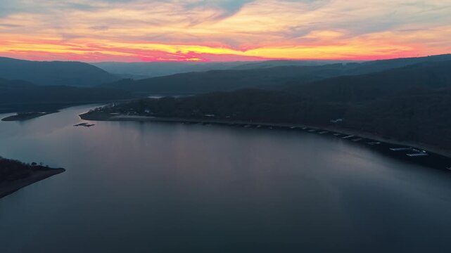 Cinematic sunset flight above the Rur Dam. Breathtaking perspectives of the landscape as day turns to night in North Rhine-Westphalia.