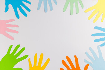 Two paper hands reaching for each other on white background for Human Rights Day representing help, support and international solidarity.