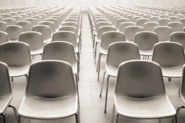 Empty seats in a large hall show the cancellation of business meetings, highlighting the impact of unexpected changes in event planning and attendance