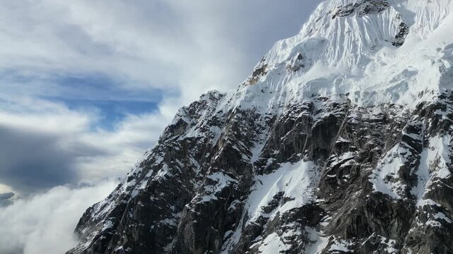 Majestic Salkantay peaks illuminated by glorious sunset, clouds rolling over dramatic Andean ridges.