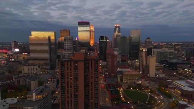 Cityscape aerial of Minneapolis during blue hour, evening lights reflecting.
