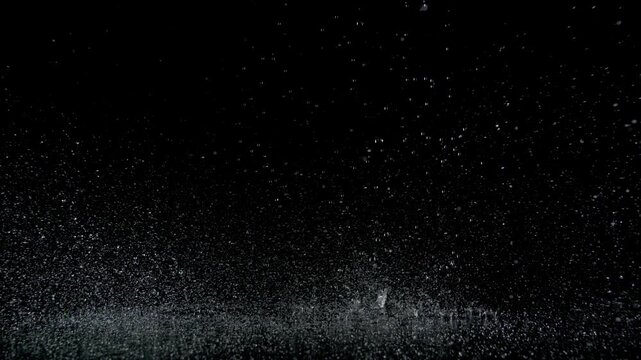 Super Slow Motion Shot of Real Raindrops Falling on a Surface, Isolated on Black, at 1000fps