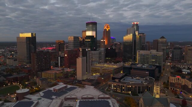 Aerial view of downtown Minneapolis during summer blue hour, city lights shimmering.