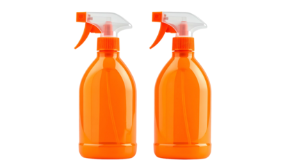 Two orange spray bottles with white trigger tops isolated on a black background