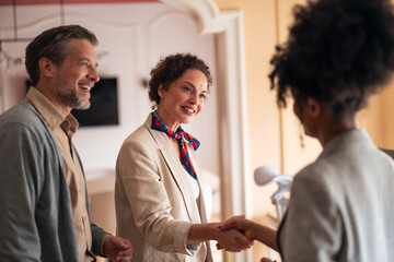Smiling Colleagues Shake Hands In Warm Indoor Setting During Meeting