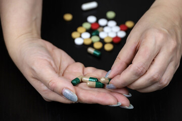Medication in capsules in a hands of woman. Concept of antibiotics, vitamins, dietary supplements