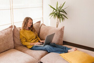 Cheerful woman using silver laptop