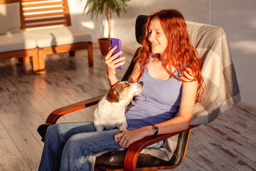 Teenage girl or young woman looks at phone at home